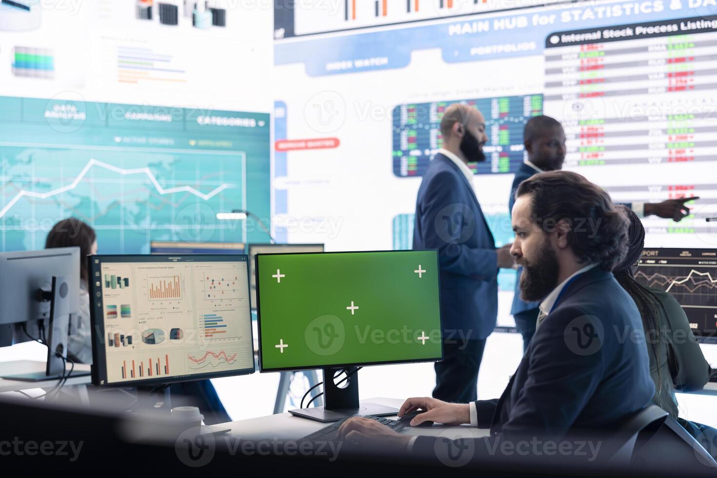 Business manager analyzes reports next to a green screen on pc, working with infographics and sales for development. Analyst consultant looks at isolated mockup display in office. photo