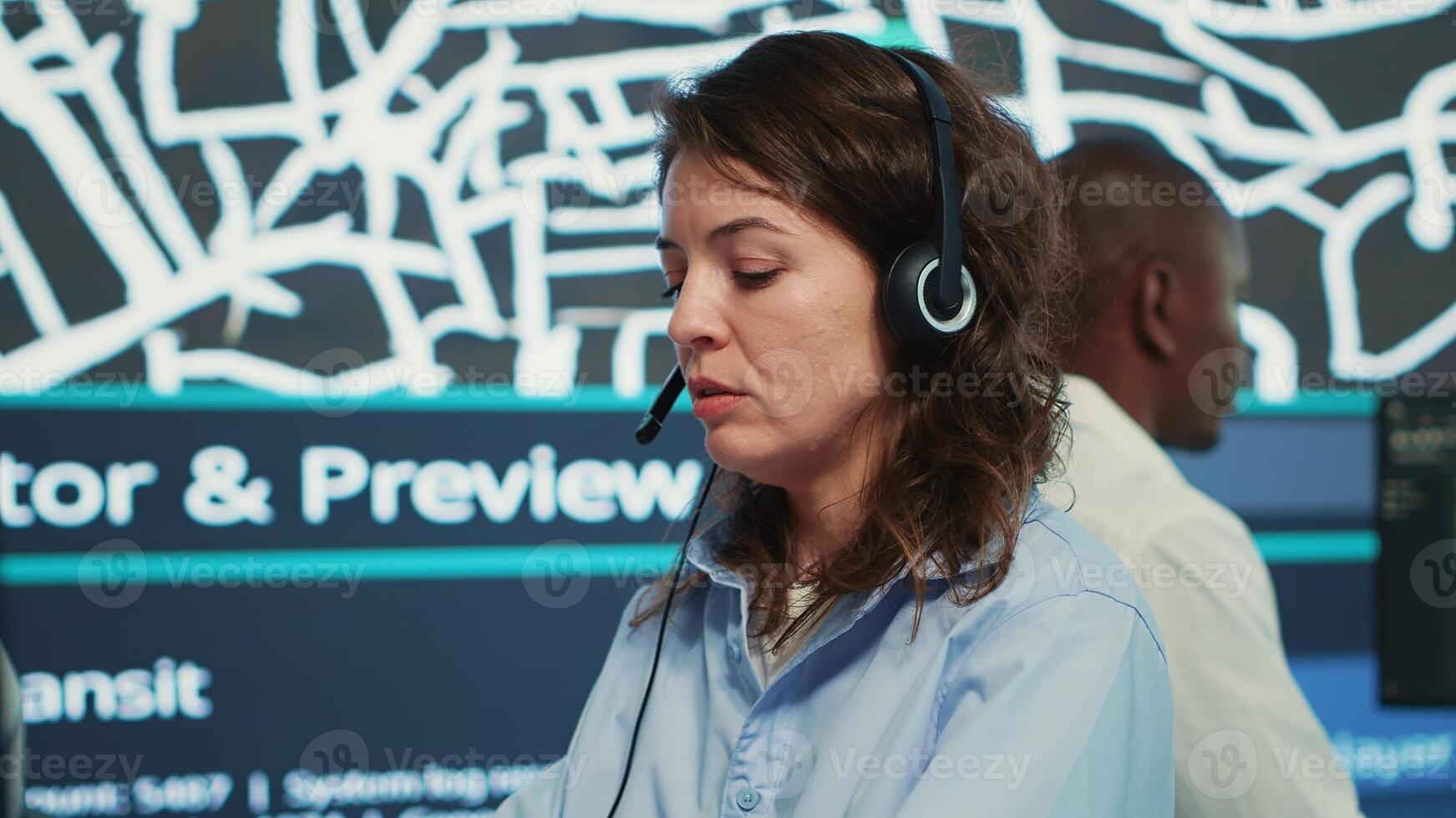 Call center employee communicating alternative routes for couriers, trying to avoid traffic by using satellite city map and surveillance CCTV footage. Operator gives gps directions. Camera A. photo