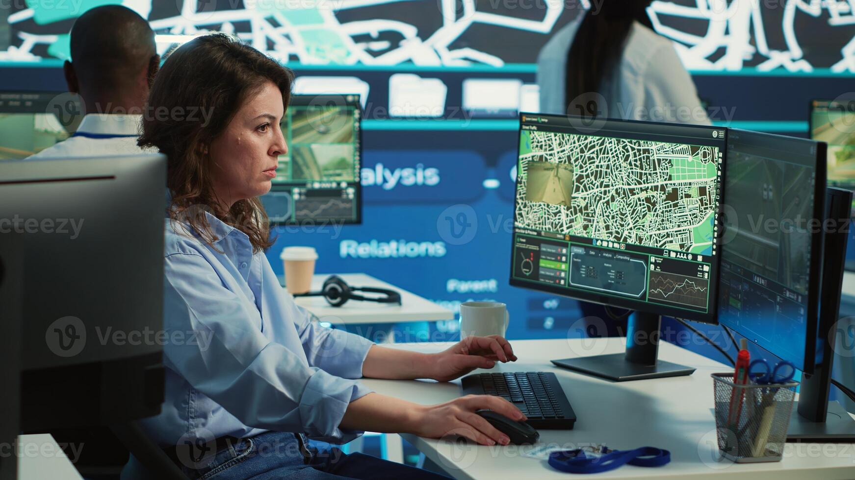 Employee navigating on satellite radar and map to search for routes, helping courier to avoid traffic and successfully deliver orders. Operator in monitoring room using gps coordinates. Camera A. photo