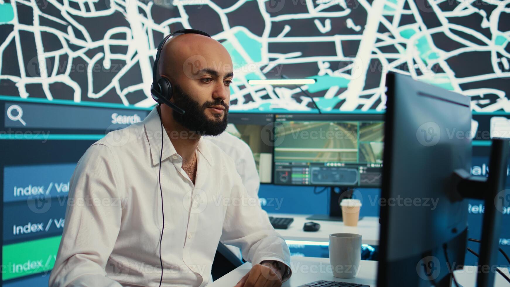 Middle eastern call center operator gives directions to the courier, avoid traffic by monitoring radar CCTV surveillance and a satellite city map. Employee helps with express delivery. Camera B. photo