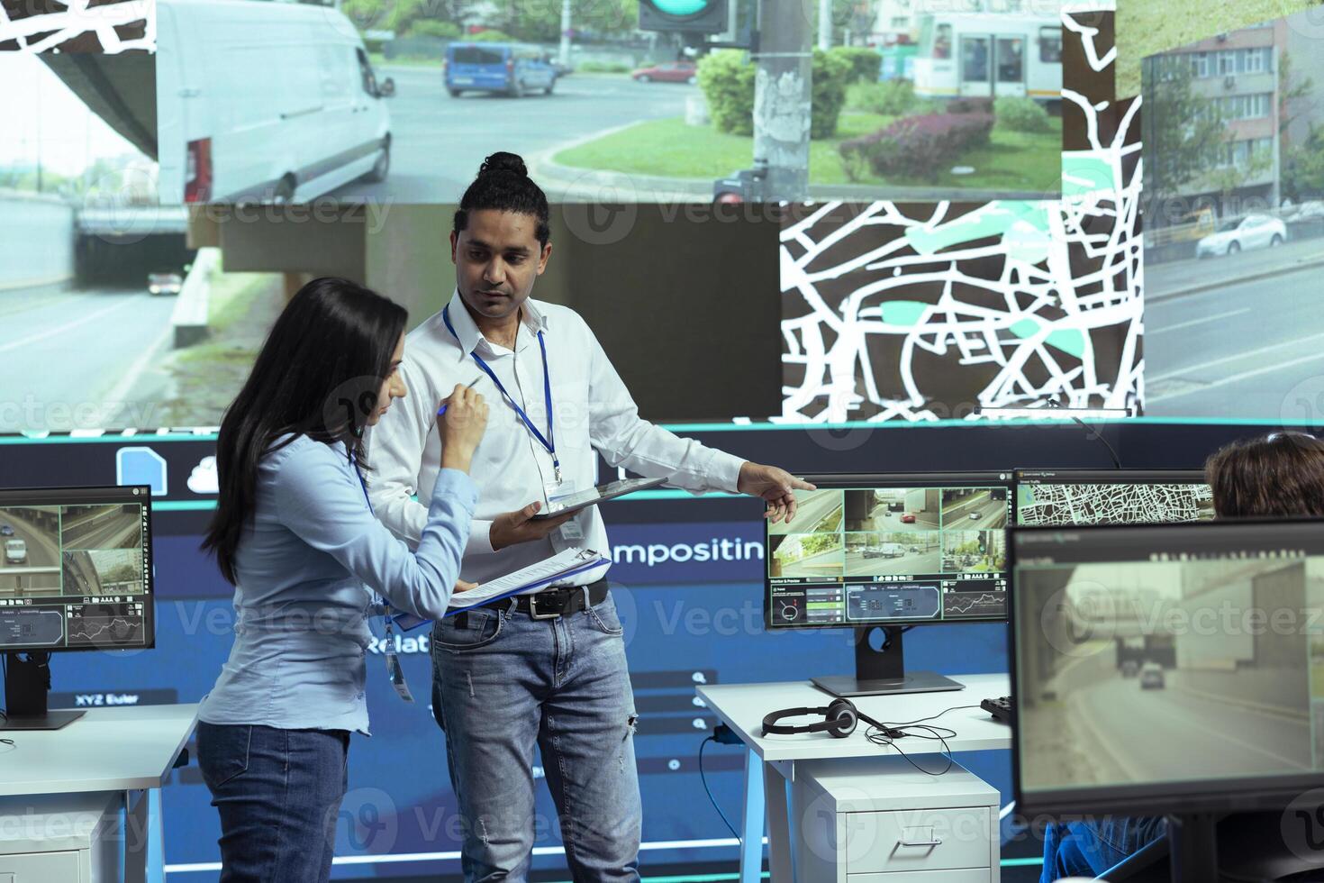 Indian operators consulting on alternative routes gps locating in control center, employees operating with CCTV footage to guide couriers in traffic. Operators follow satellite navigation. photo