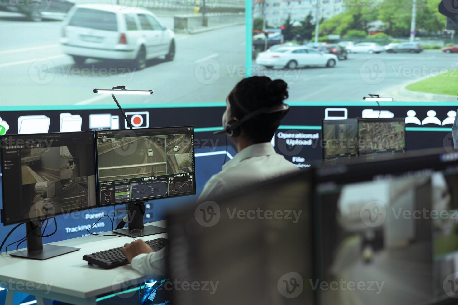 Indian agency employee working to monitor surveillance footage on a big screen, supervising traffic flow around the city. Government headquarters operating CCTV satellite and radar system. photo