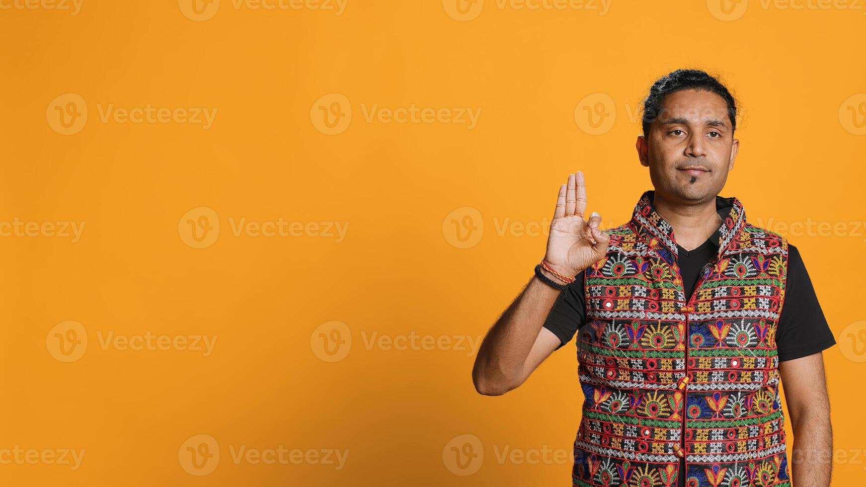 Indian man doing ok hand sign, feeling pleased, agreeing with satisfactory conclusion. Optimistic person doing okay symbol gesturing, offering positive feedback, studio background, camera A photo