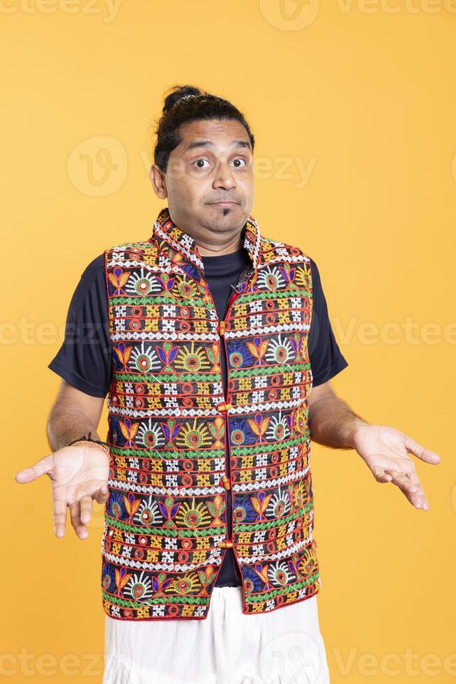 Portrait of doubtful man shrugging shoulders, unable to provide answer, isolated over studio background. Hesitant person doing perplexed hand gesturing, showing lack of knowledge photo