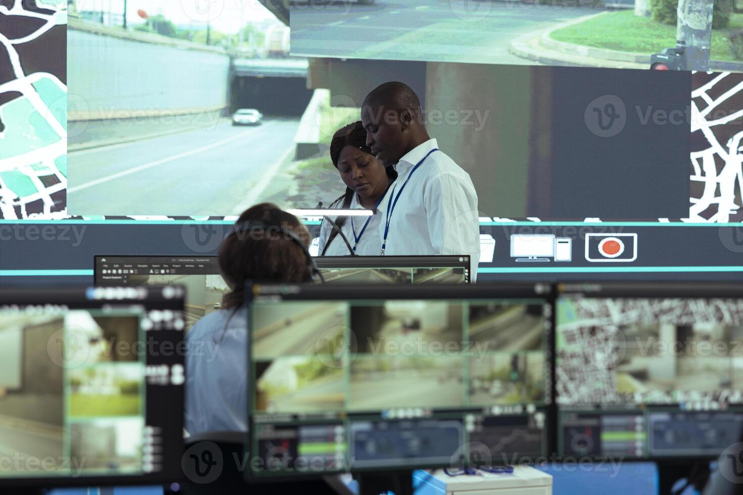 African american team leaders inspecting delivery trucks activity in traffic, ensuring easy order shipment with satellite navigation through radar system. Analyzing CCTV surveillance footage. photo