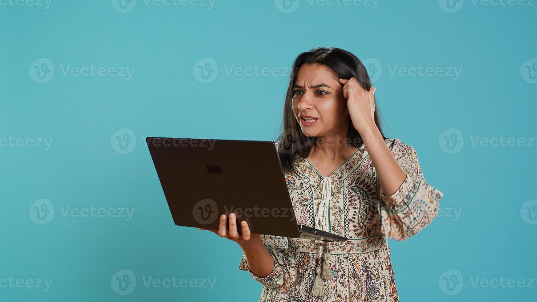 Irked woman fighting with coworkers during videocall on laptop, isolated over studio background. Outraged person arguing with colleagues during conversation on notebook, camera A photo