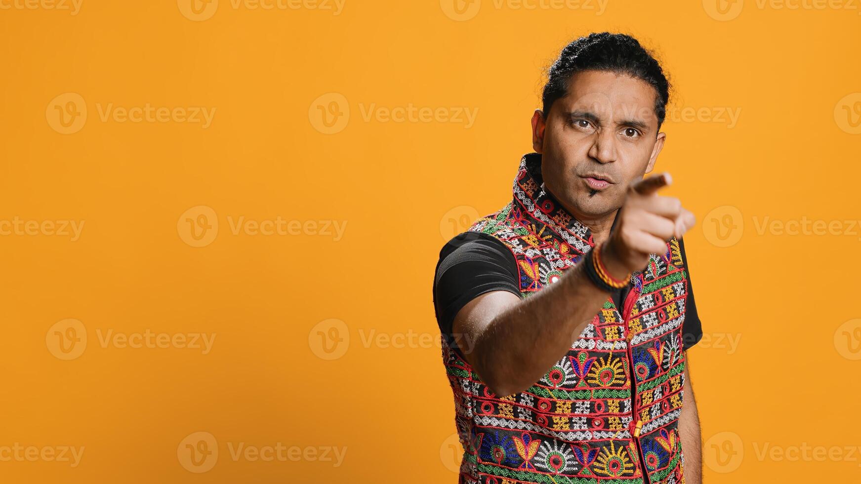 Disappointed indian man admonishing friend over debacle, isolated over studio background. Upset person in disagreement with mate, pointing finger and lecturing him, camera A photo