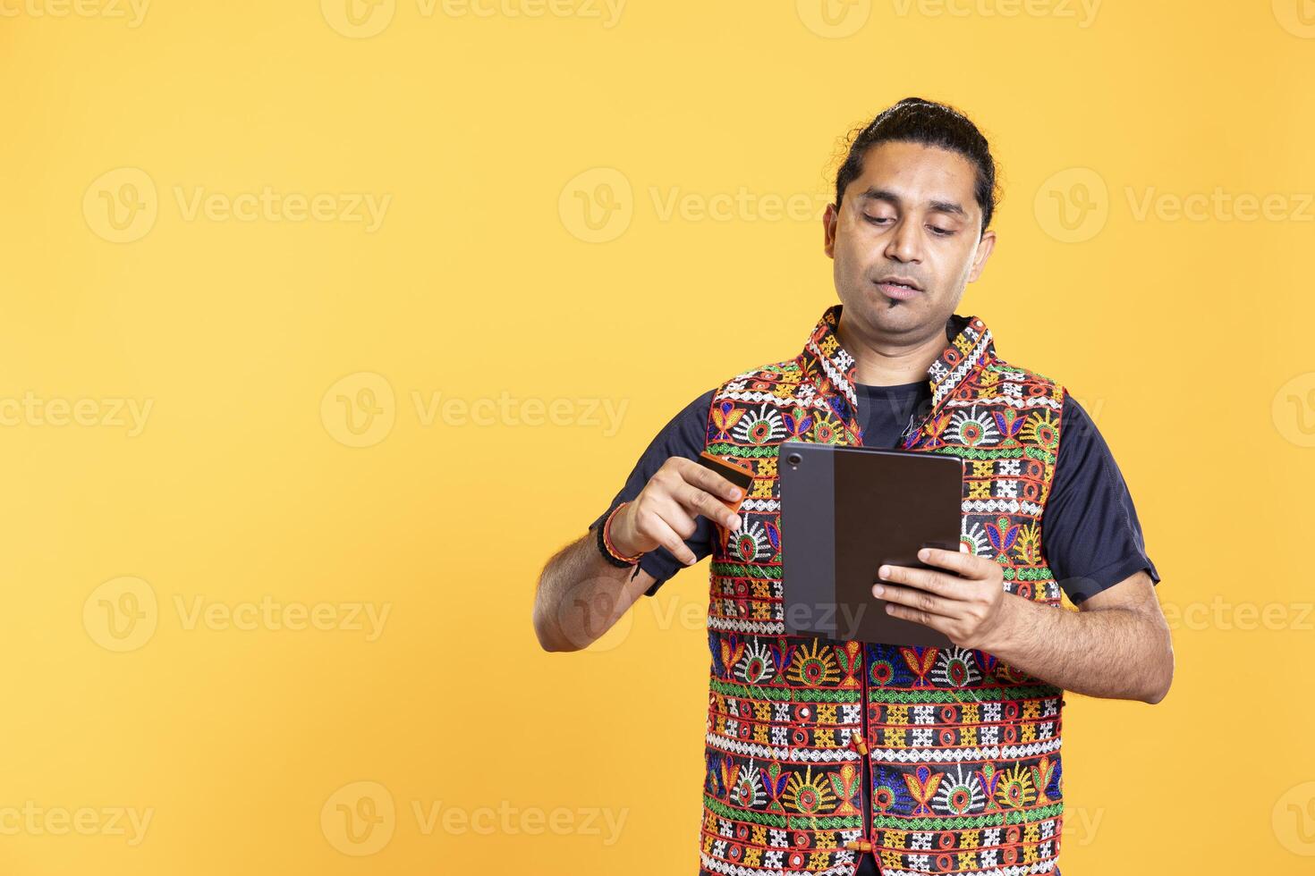 Man with dejected look on face after lacking necessary money, trying to buy stuff online. Person with disappointed facial expression after getting transaction rejected on device, studio background photo