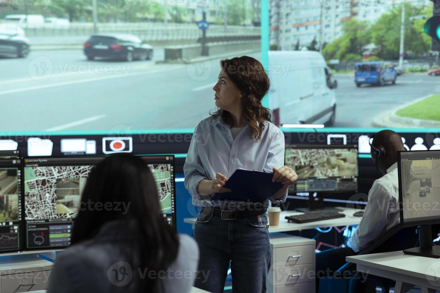 Young manager reviewing traffic surveillance data with her staff team, using the CCTV security system for license plate reading around the city. Agency employee uses satellite radars. photo