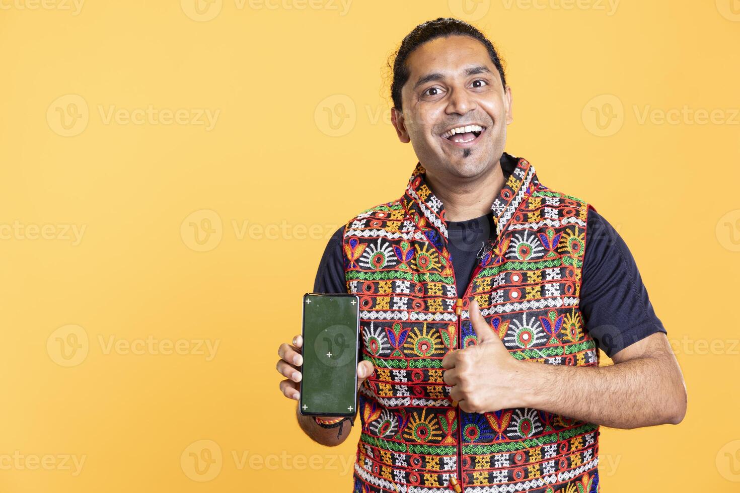 Portrait of excited content creator influencer smiling and doing thumbs up gesturing presenting isolated screen mobile phone. Thrilled person holding mockup cellphone, doing positive hand gesture photo
