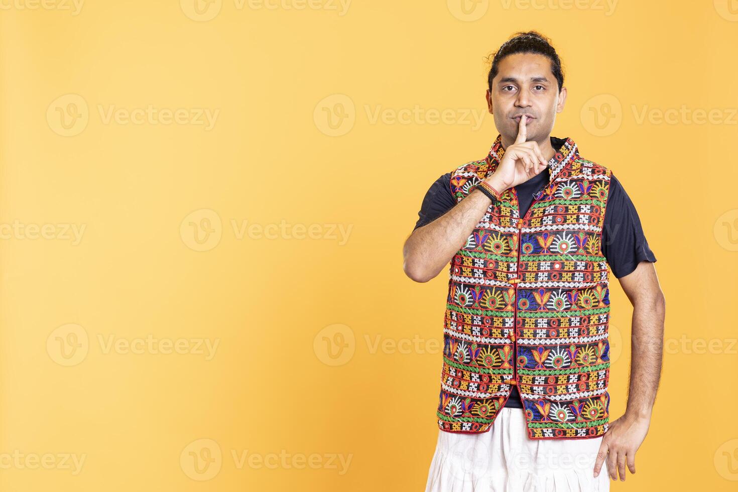 Annoyed man doing shushing hand gesturing, irritated by noise, having negative mood. Person placing finger on lips, doing quiet sign gesture, isolated over studio background photo