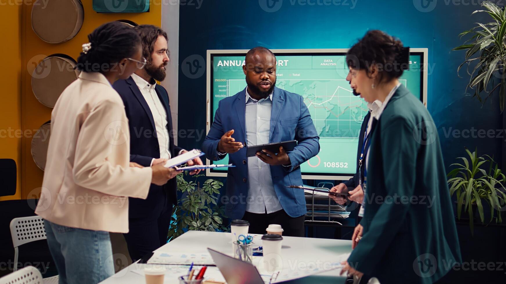 Supervisor and employees attend a status update meeting with their progress portfolios on the current business project. Team leader reviewing marketing strategies and budget planning. Camera B. photo