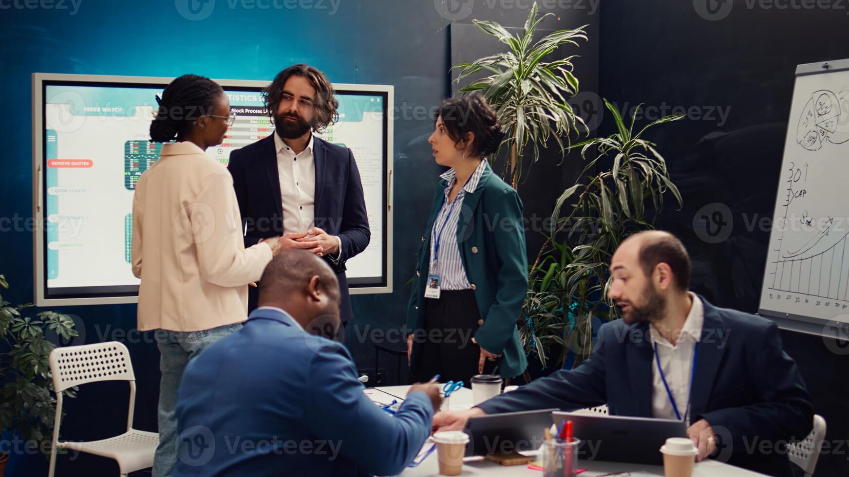 Team of startup colleagues preparing their presentation speech in front of the interactive board. Office employees meeting in a boardroom to review performance metrics as a group. Camera B. photo