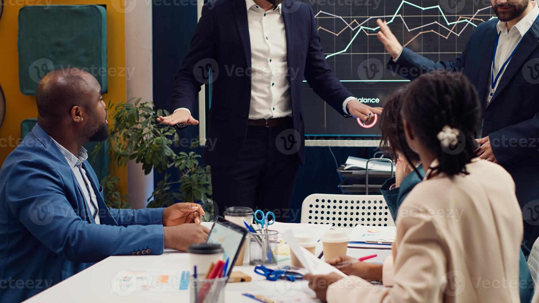 Project managers making a presentation with annual reports to evaluate statistics and understand what can be improved, problem solving meeting. Team identifying issues to ease workflow. Camera A. photo