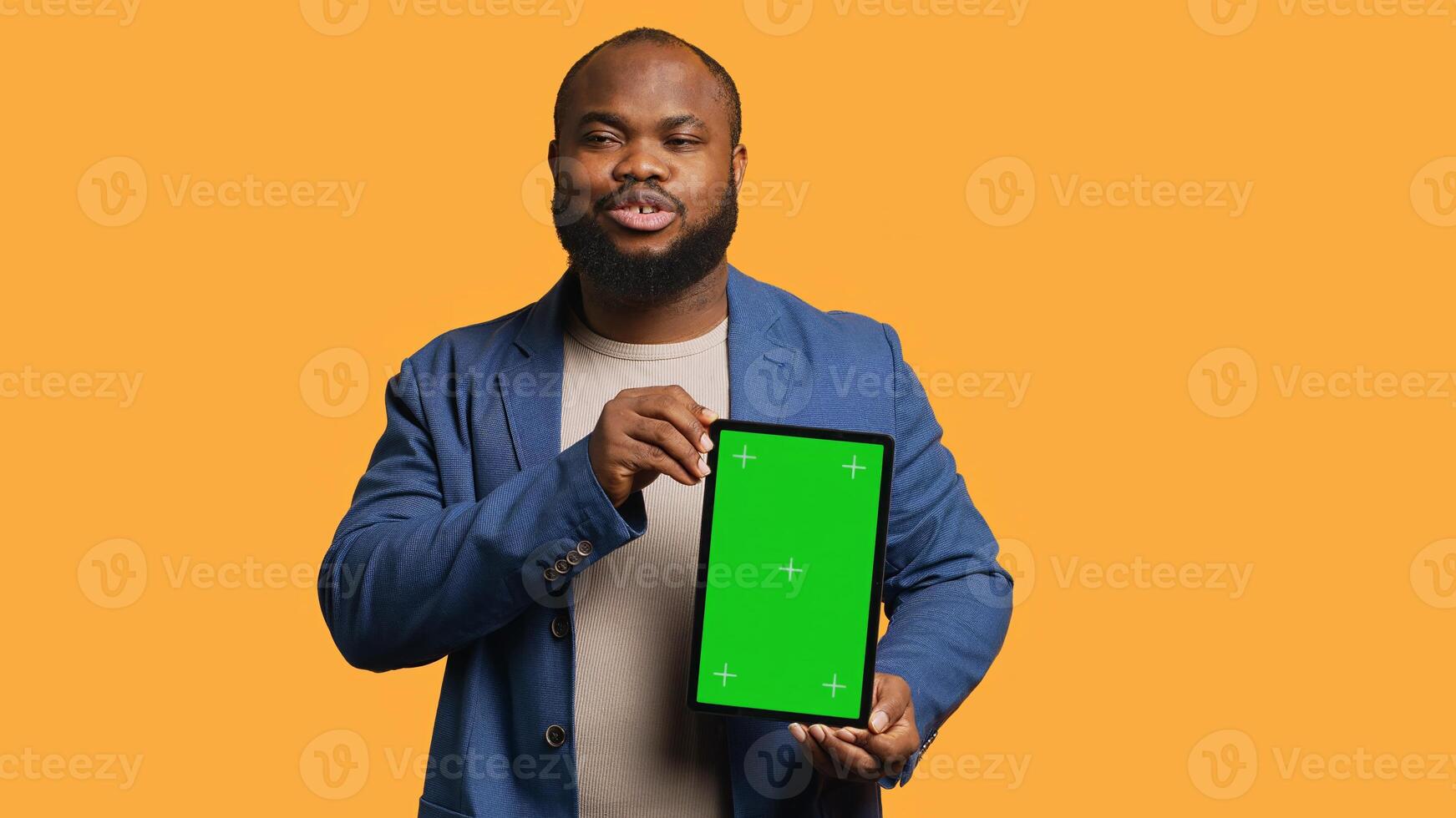 Portrait of african american man doing influencer marketing using green screen tablet, studio background. Smiling BIPOC person holding empty copy space mockup device, camera A photo