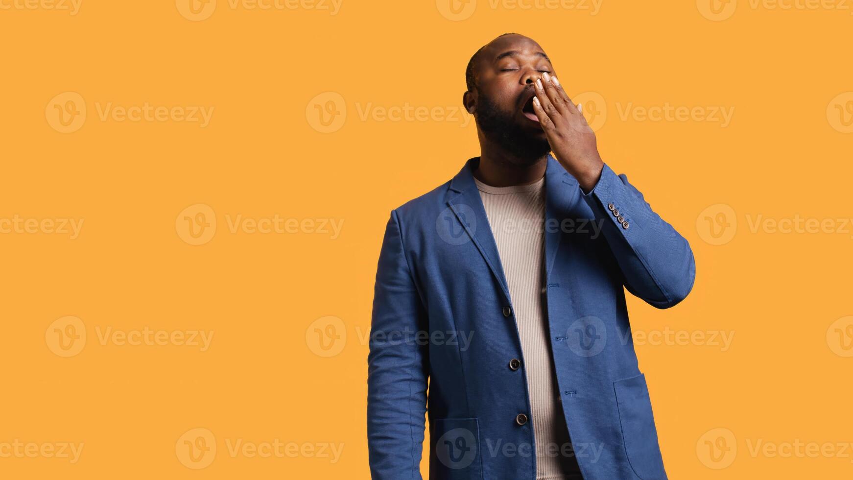 African american man feeling exhausted from overworking and lack of sleep, suffering from headache and yawning, studio background. Tired BIPOC person feeling migraine from fatigue, camera B photo