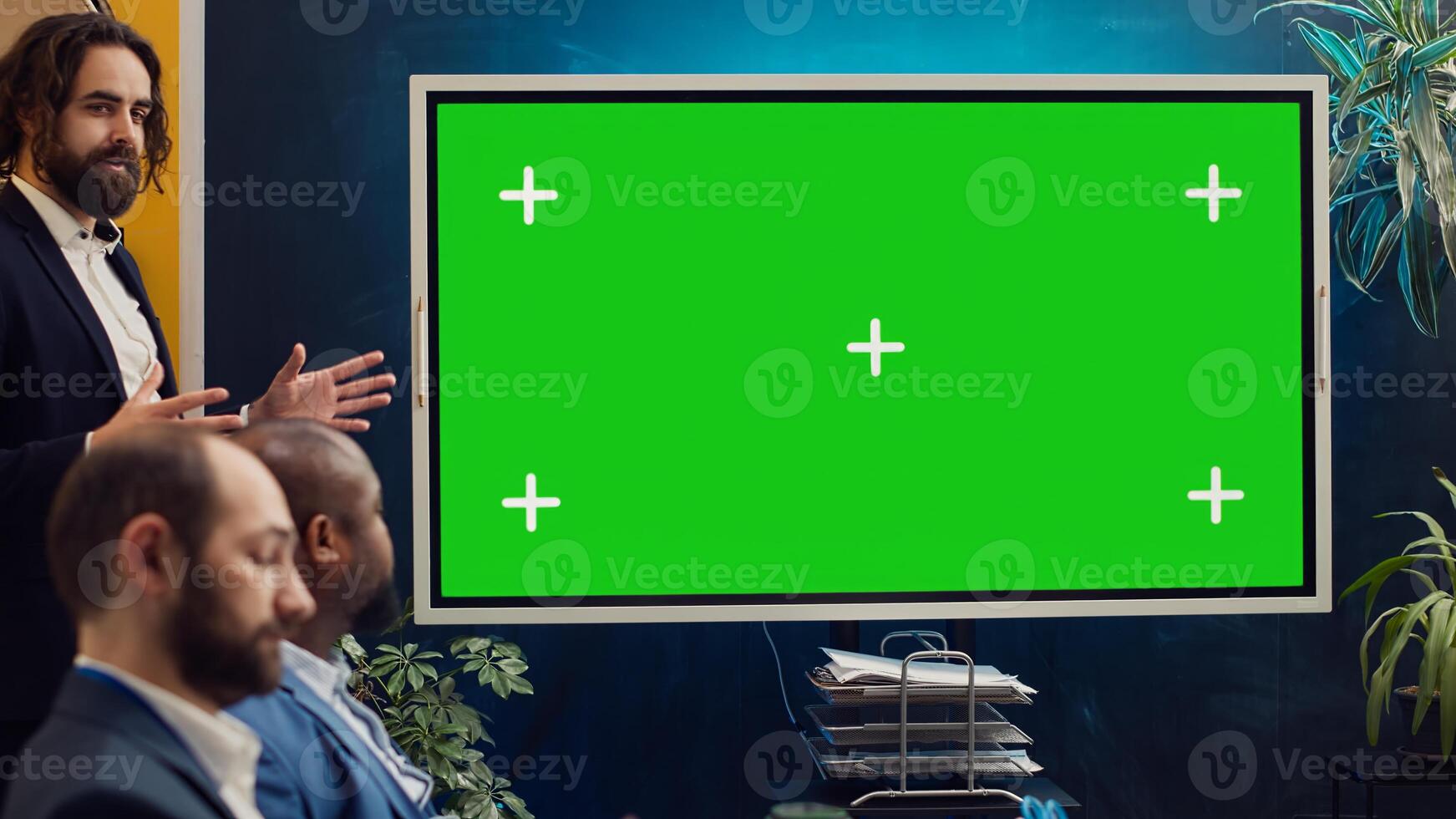 Sales management team working with isolated copyspace display in a briefing meeting, sharing ideas and practices to improve workflow. Organization affiliates gathered in a conference. Camera A. photo