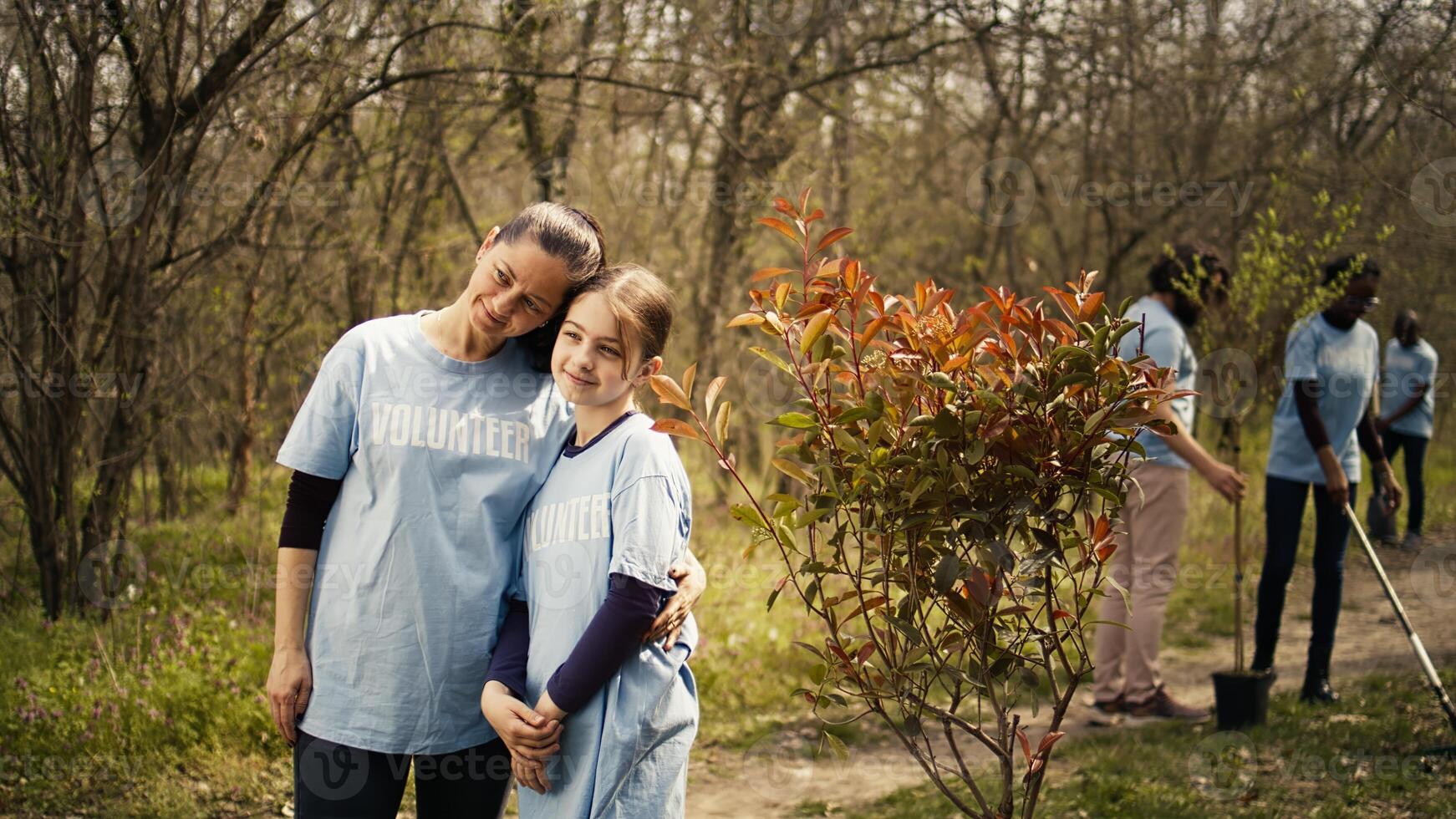 Portrait of mother and daughter volunteering to clean up a forest area, showing a sense of devotion and responsibility for the natural environment conservation. Ecological justice. Camera B. photo