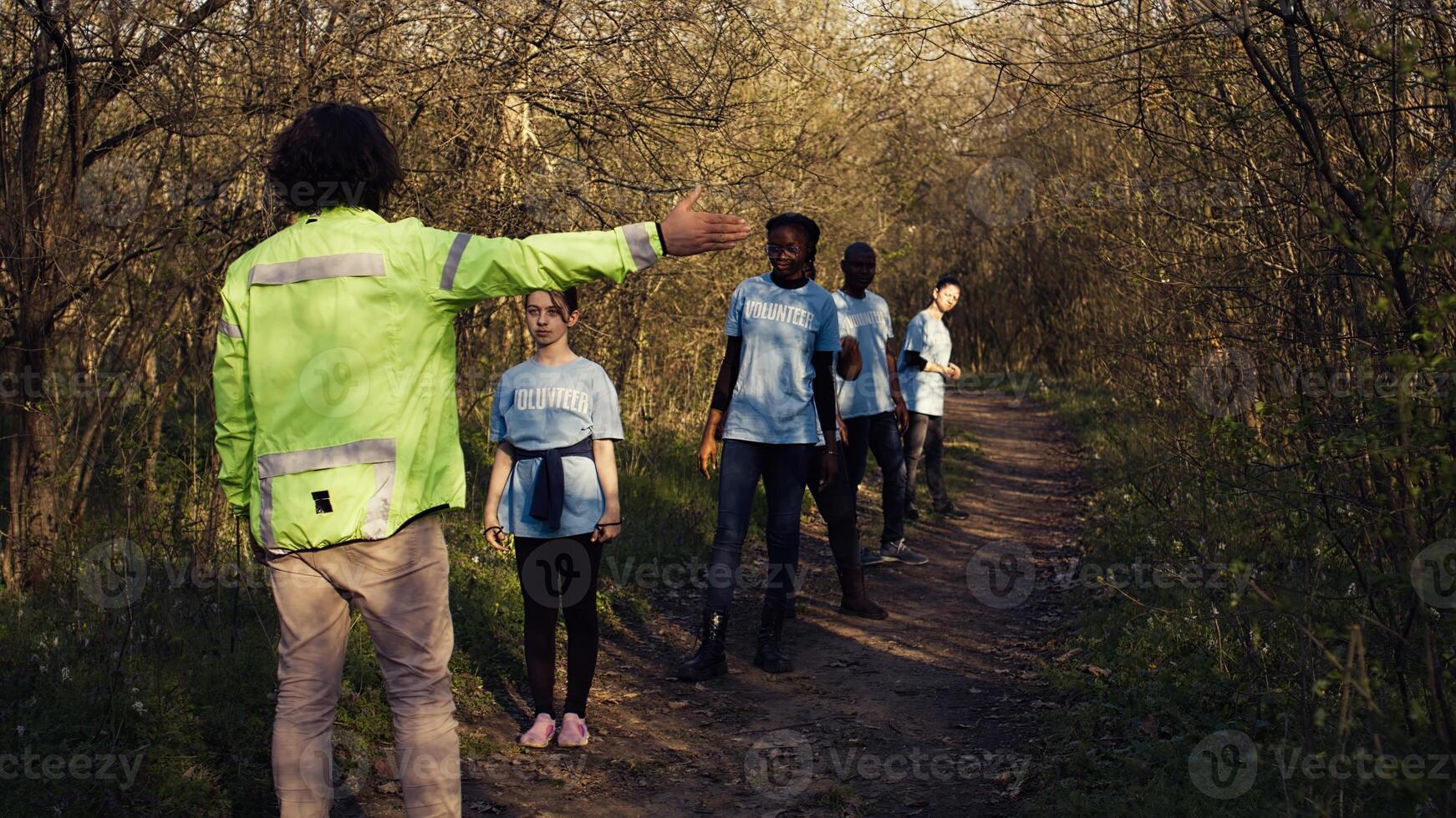 As the mission for the lost individual grows worse, supervisor of the rescue operation team guides his crew into the forest in search of clues. People screaming for missing person's name. Camera B. photo