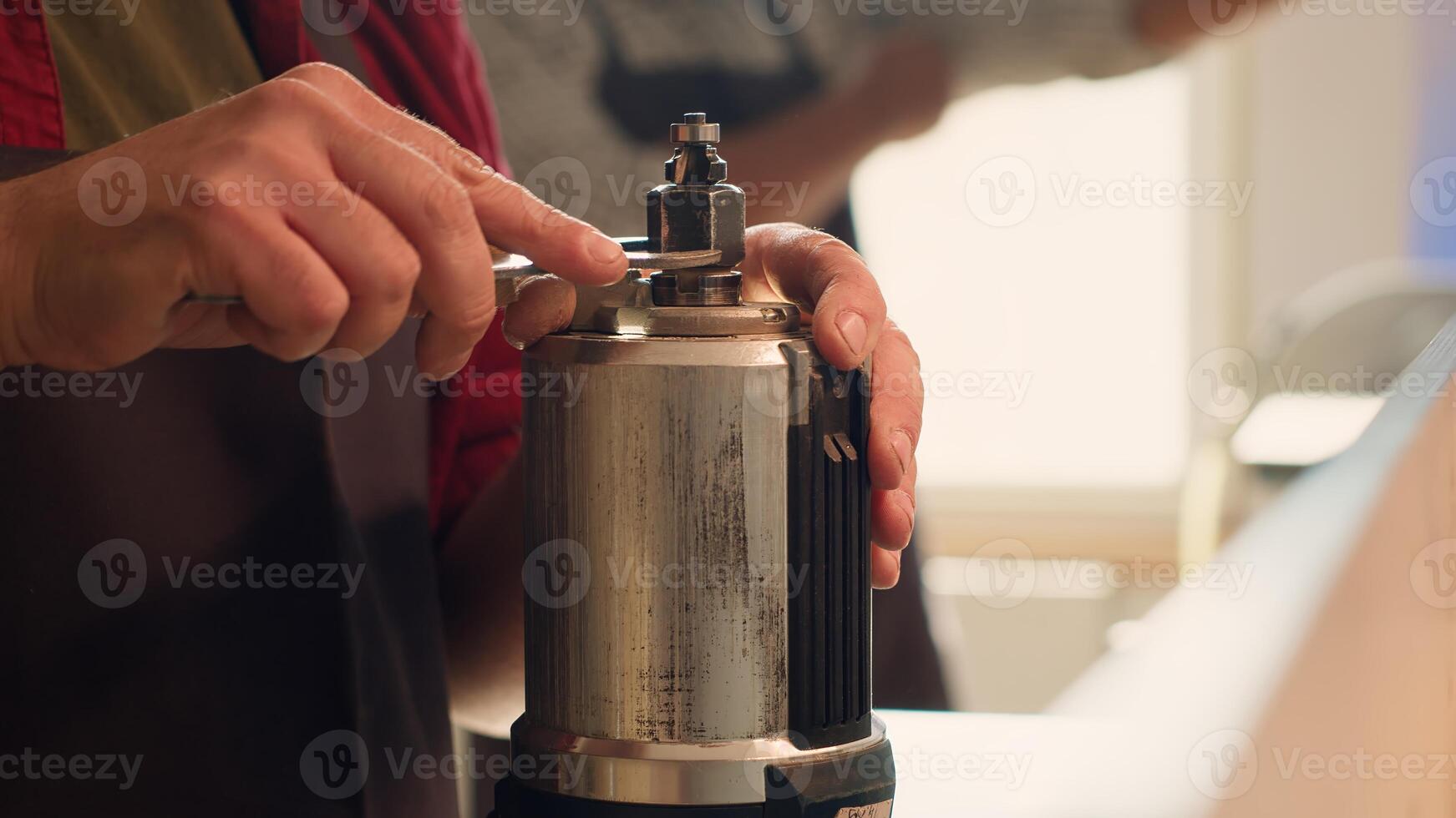 Serviceman in furniture assembling shop changing rotor part on spindle moulder machinery. Engineer in woodworking studio fixing defective wood shaper, replacing damaged component, camera A photo
