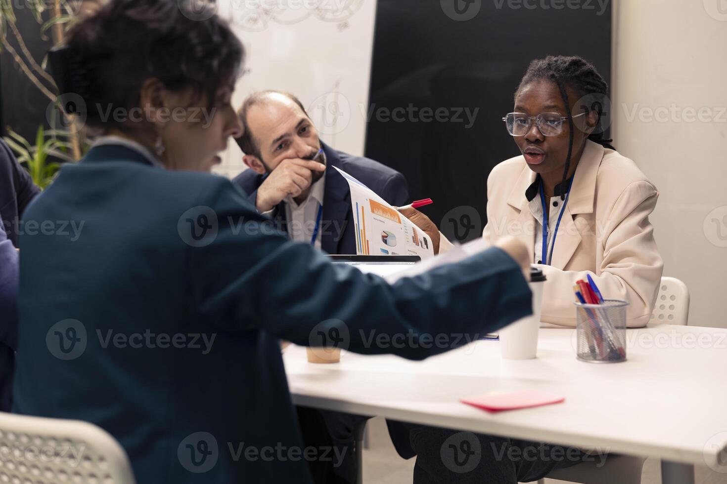 Team of colleagues working on resource allocation initiatives during a conference, making important budgeting decisions to corelate with business goals and objectives. Employees review strategies. photo