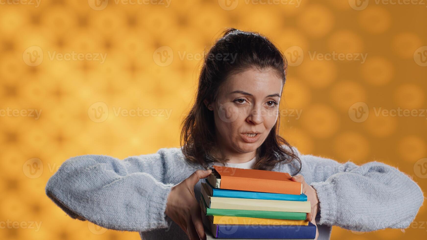 Woman choosing between physical books and ebooks, favoring ereader for lightness, studio background. Bookworm picking digital literature on tablet in front of heavy stack of novels, camera A photo