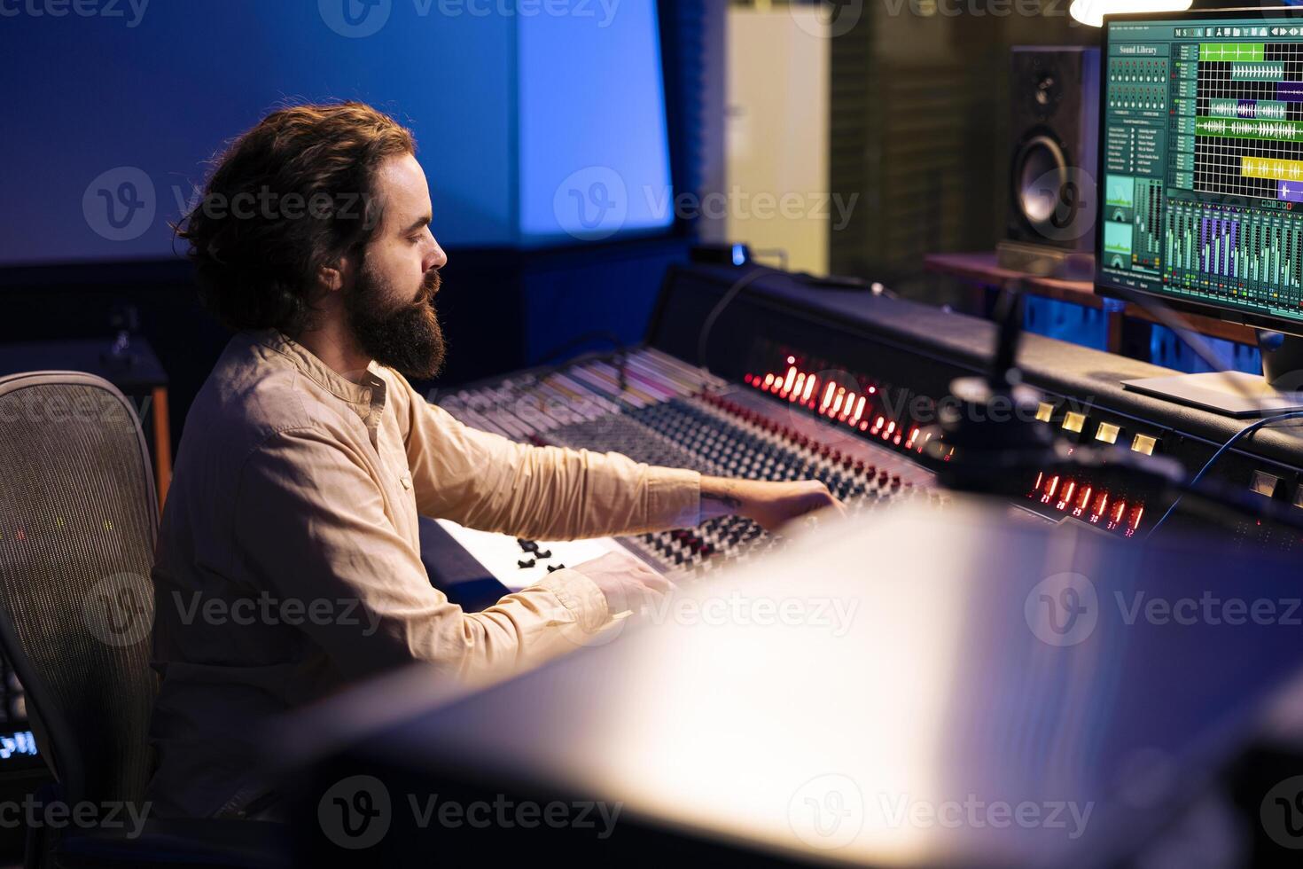 Control room audio engineer processing and mixing sounds with sliders and knobs, working on music post production in professional studio. Technician producing tracks on electronic console. photo