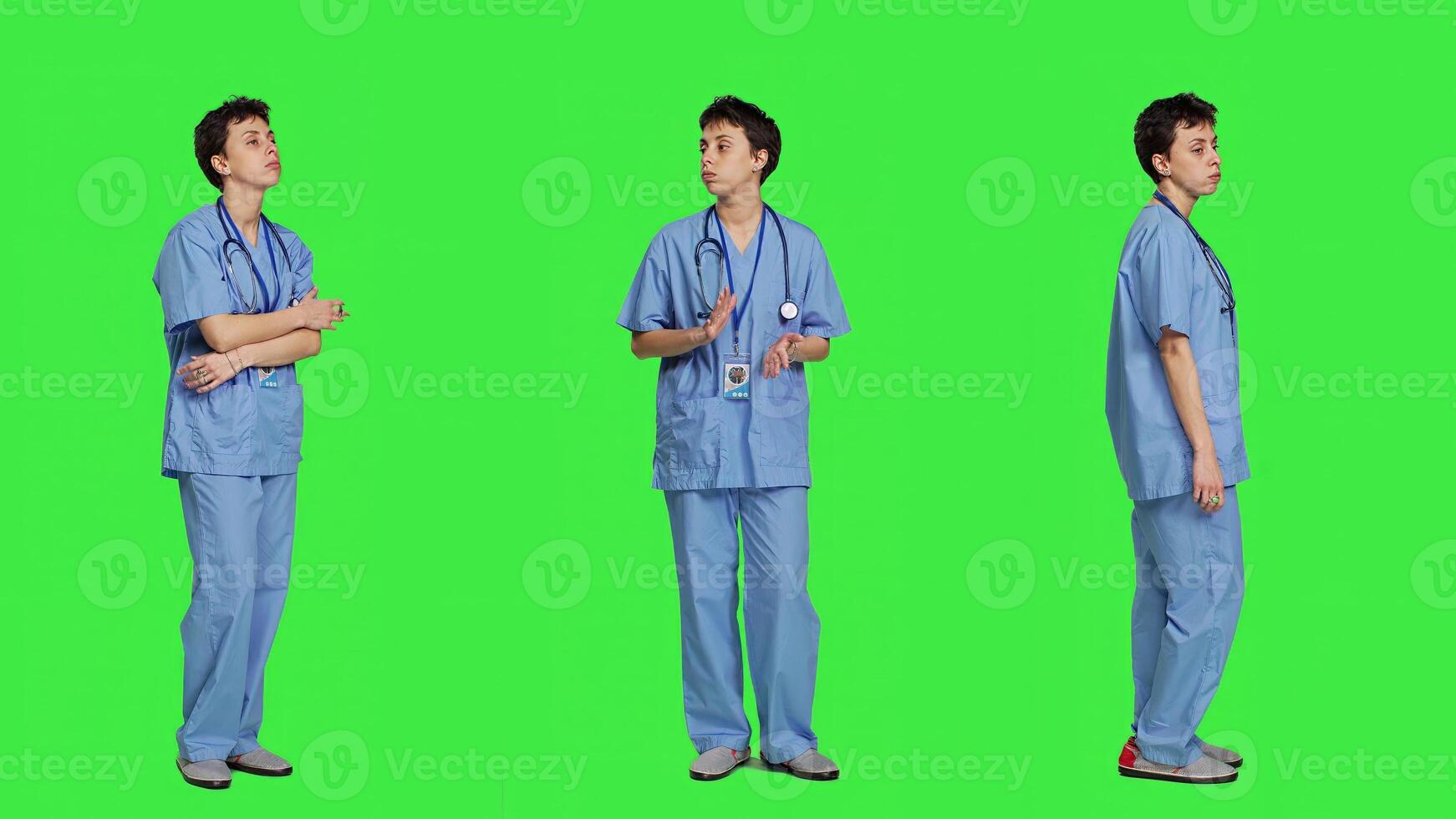 Impatient nurse acting frustrated while she waits for patients at clinic, standing against greenscreen backdrop. Worried nurse with blue scrubs waiting for people to arrive at checkup. Camera A. photo