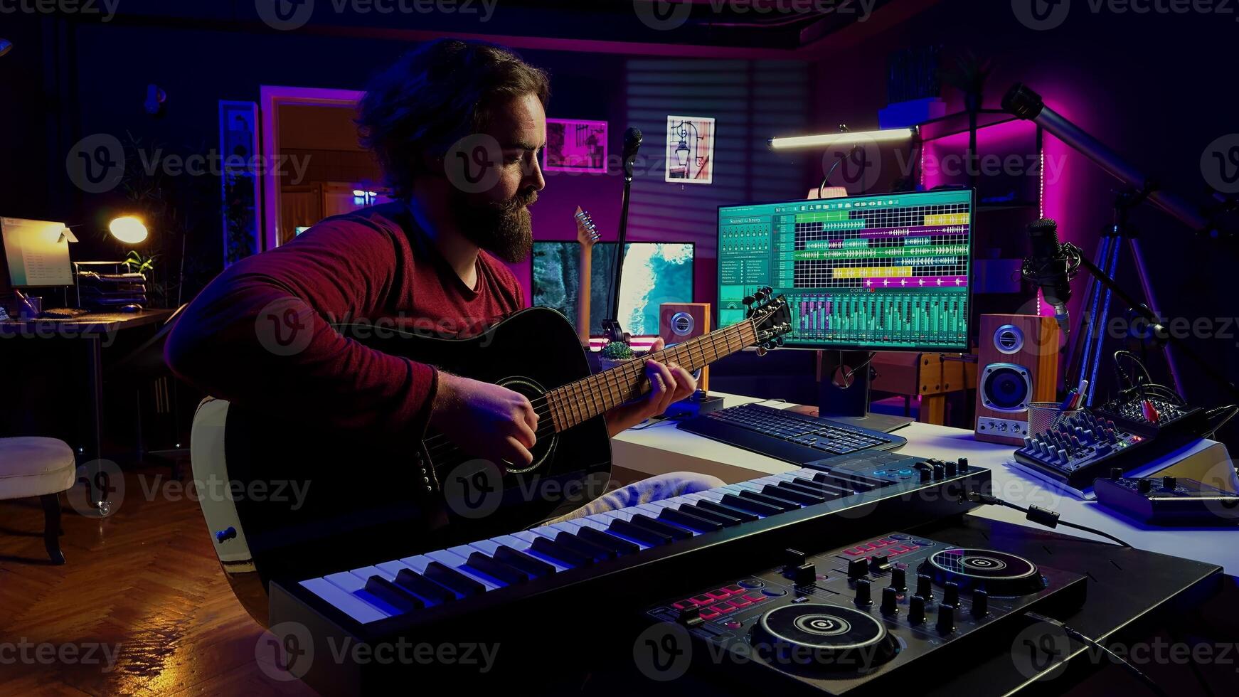 In home studio, music engineer practices acoustic guitar and writes songs, entertaining himself with amplification devices and musical tools. Skilled musician performer producing a tune. Camera A. photo