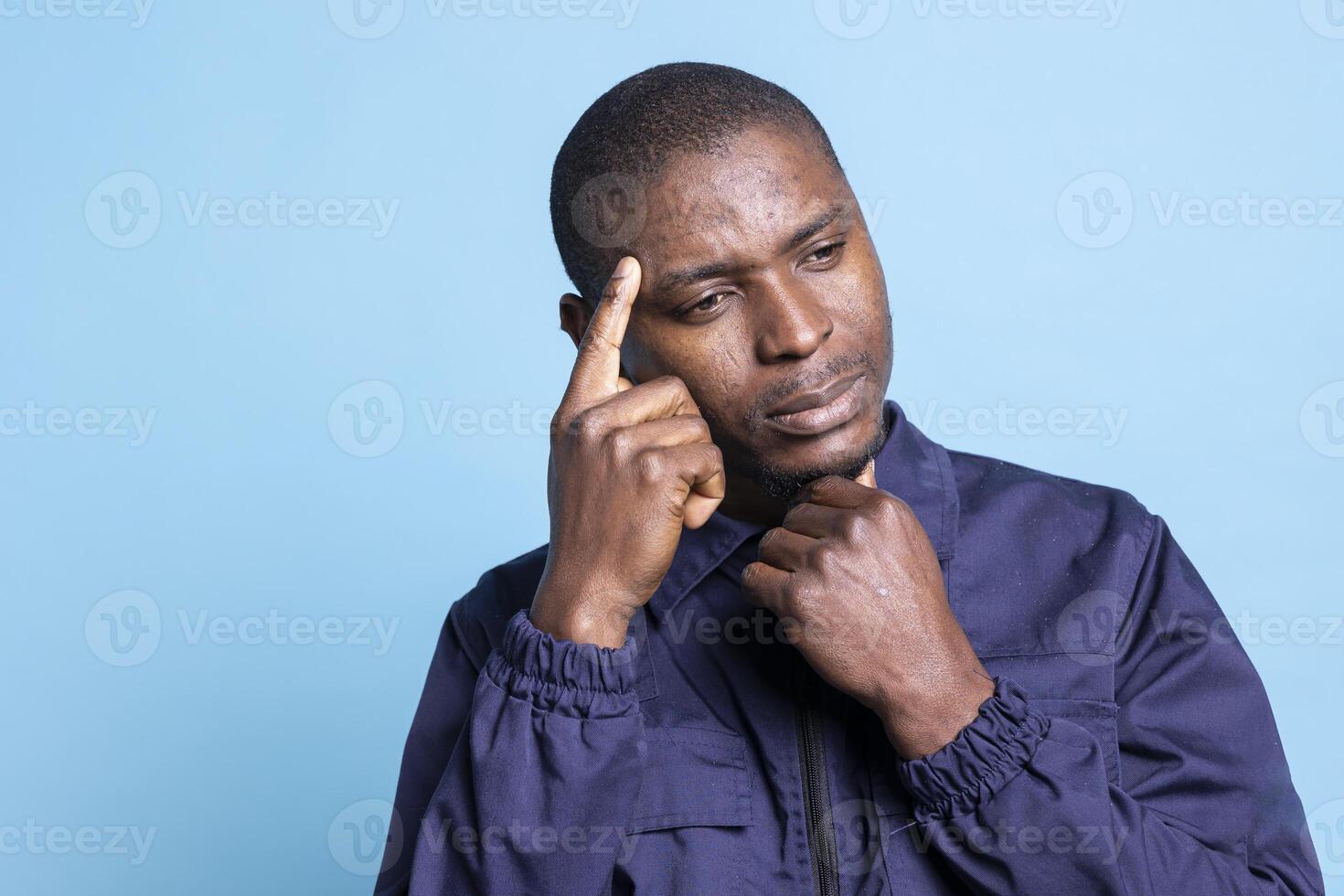 Pensive security guard thinking of ways to ensure wellbeing on camera, duty of protecting and safeguarding the area. Thoughtful agent in professional uniform contemplates on safety measures. photo