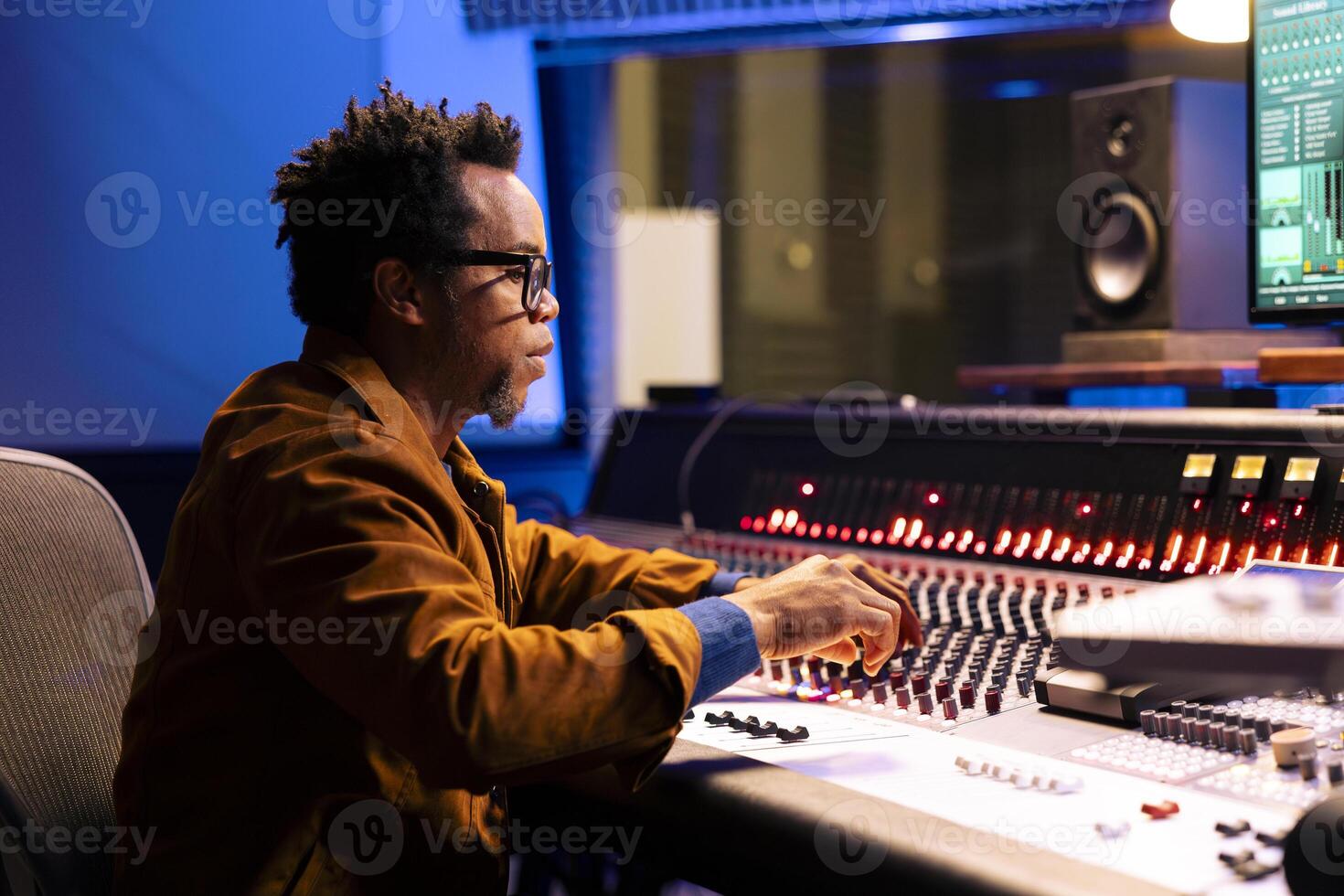 Music producer operating audio console in control room with professional editing and mixing equipment, post production concept. Sound designer processing tracks, digital software. photo