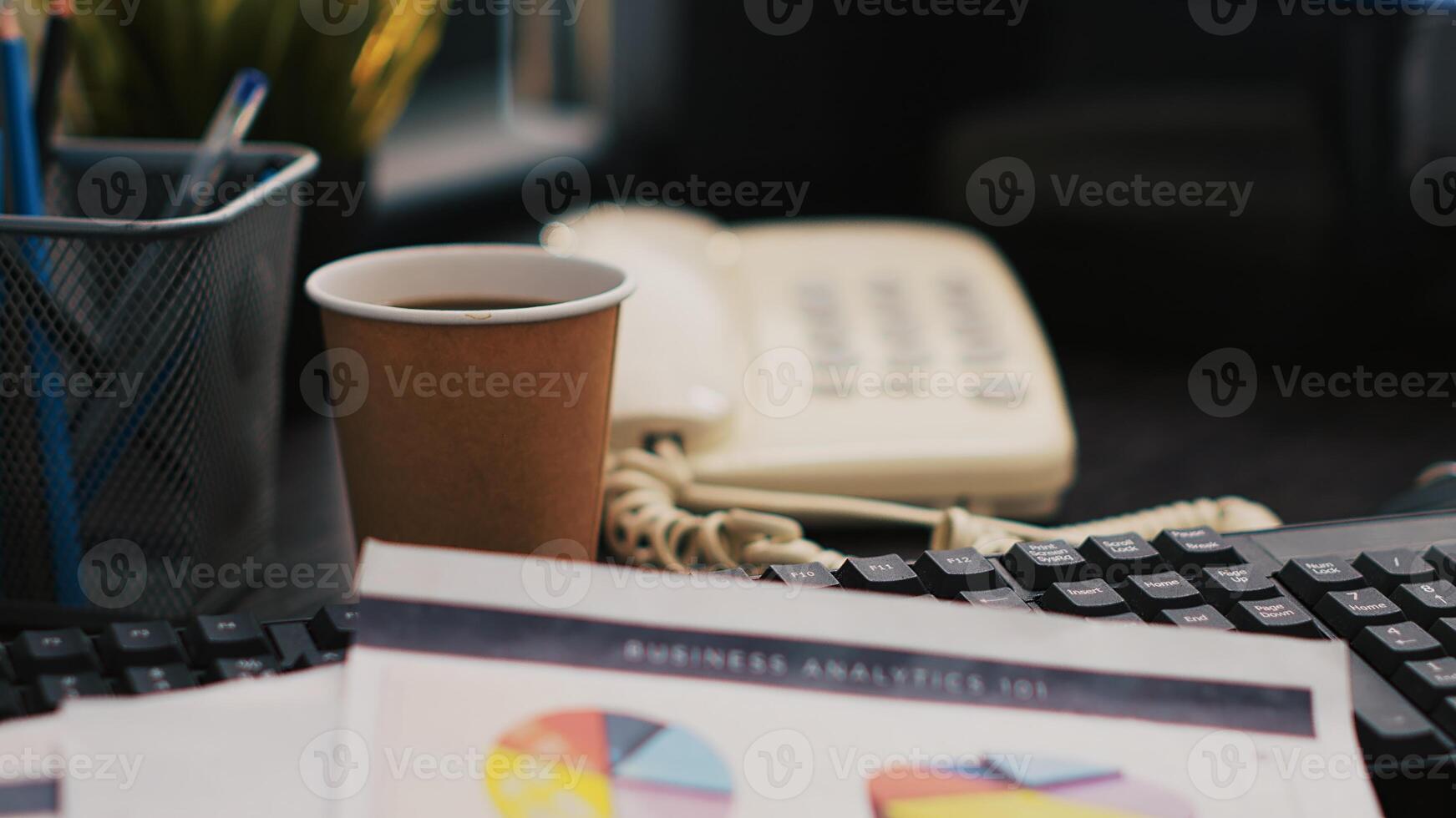 Corporate project investments report on desk next to paper cup of coffee, close up shot. Bookkeeping documents containing business analytics near hot beverage on table in office photo