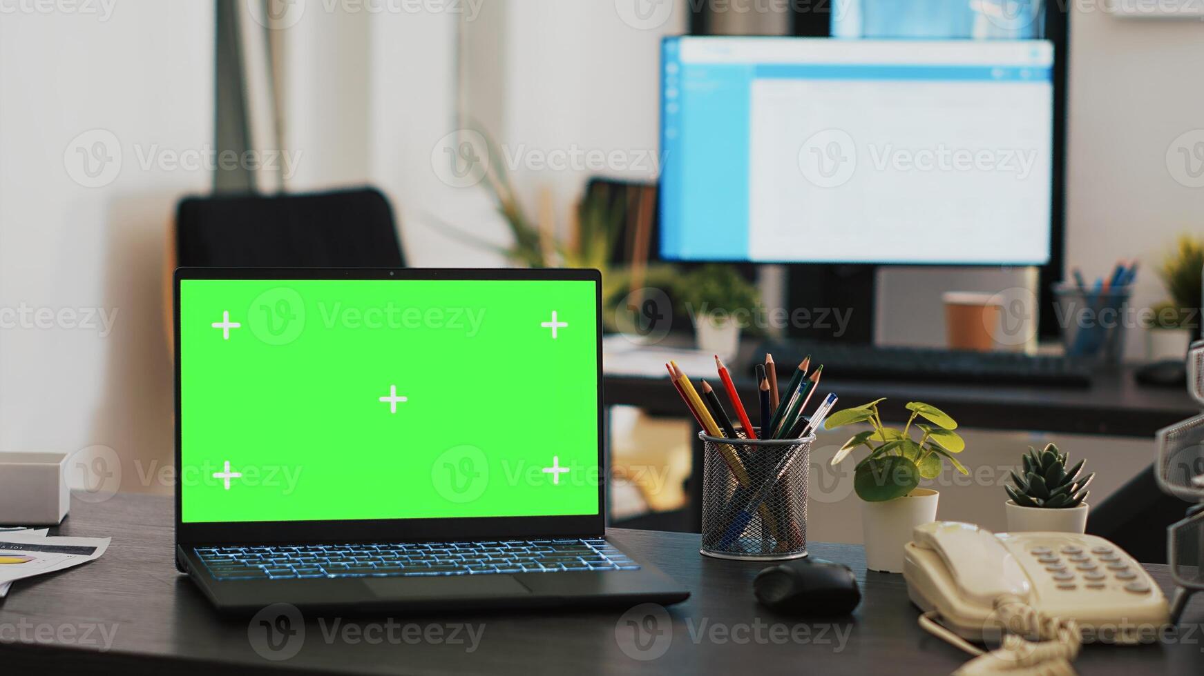 Office with green screen laptop and display in background with clients appointment list, panning shot. Chroma key notebook in financial department and customers schedules list in the back on monitor photo