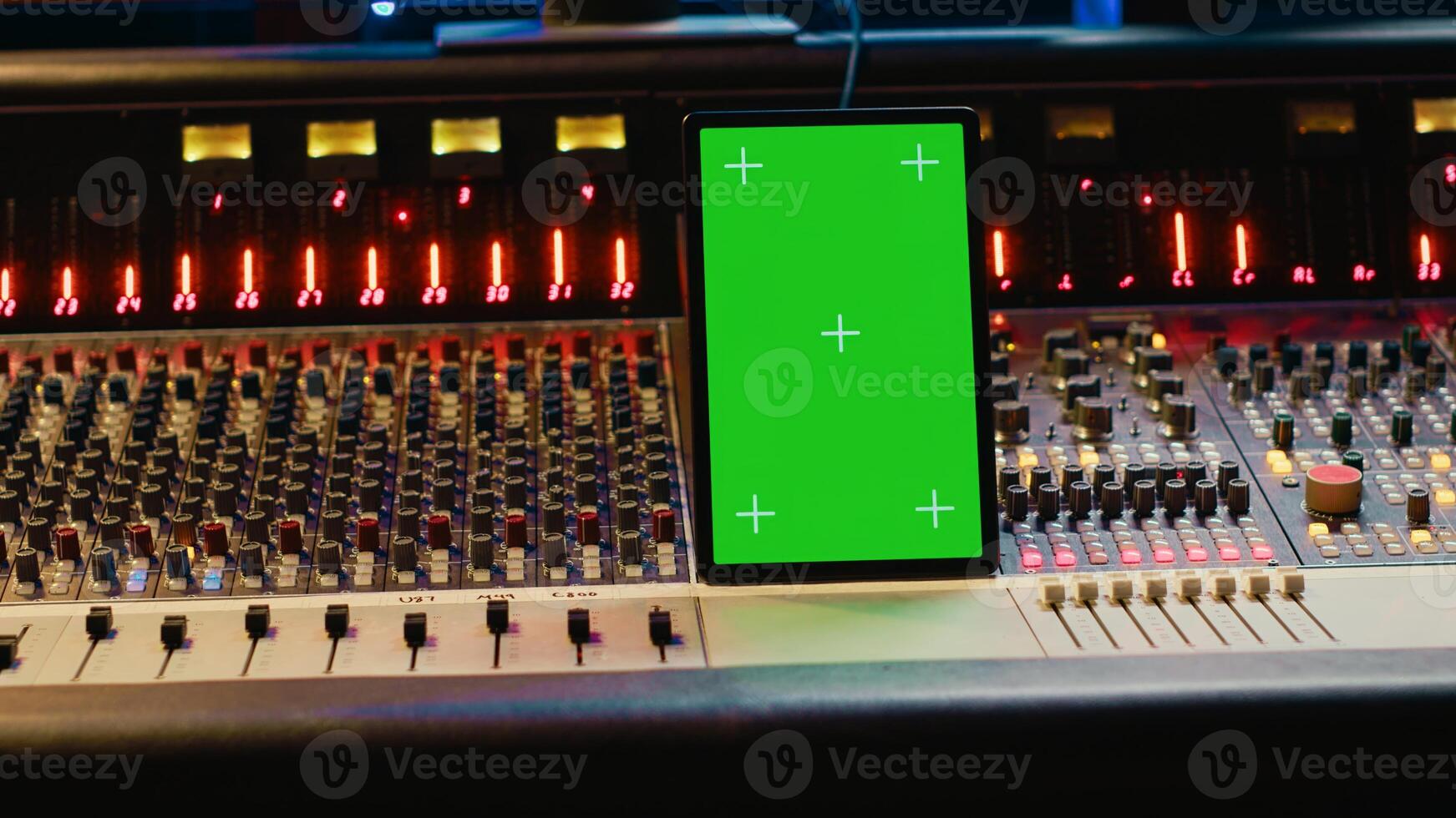 Professional audio expert mixing and mastering tracks in music production studio, pushing buttons and switchers in control room. Sound engineer recording tunes with greenscreen tablet. Camera A. photo