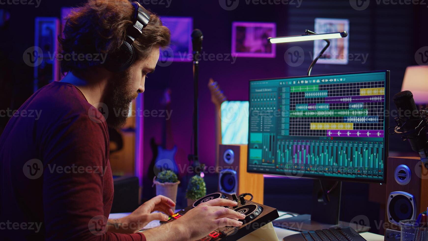 Music producer recording piano keyboard notes and editing them on a mixing console in his home studio. Skilled artist implementing advanced sound mixing techniques, equalization tools. Camera B. photo