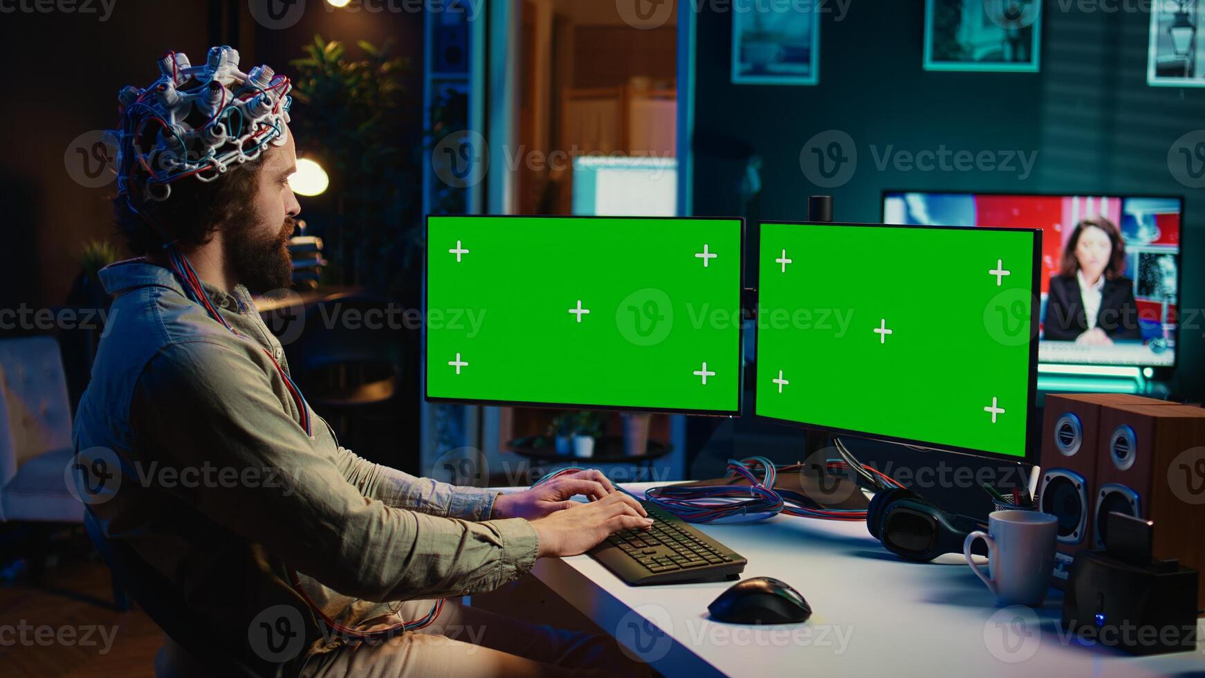 Engineer with EEG headset on programming brain transfer into computer virtual world on isolated screen monitors. Transhumanist using neuroscience to gain digital soul through chroma key PC, camera B photo