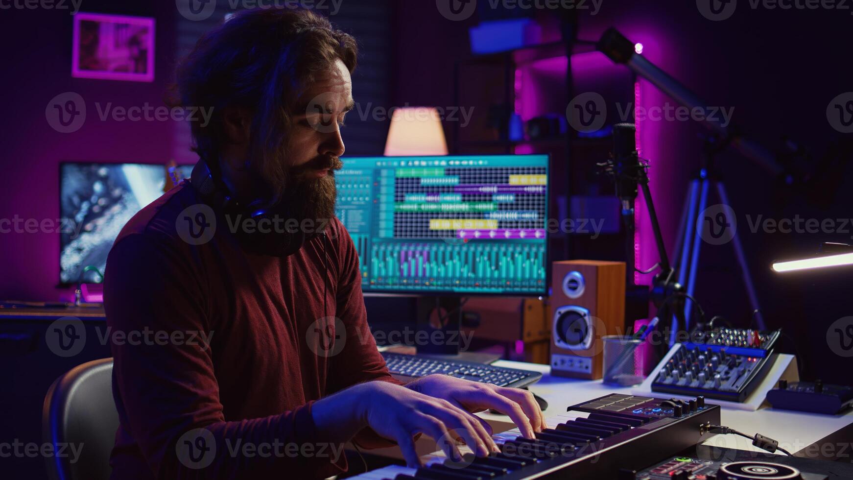Audio engineer doing recording session with piano keyboard in home studio, mixing and mastering sounds to create new music. Musician playing midi controller synthesizer, producing tunes. Camera B. photo