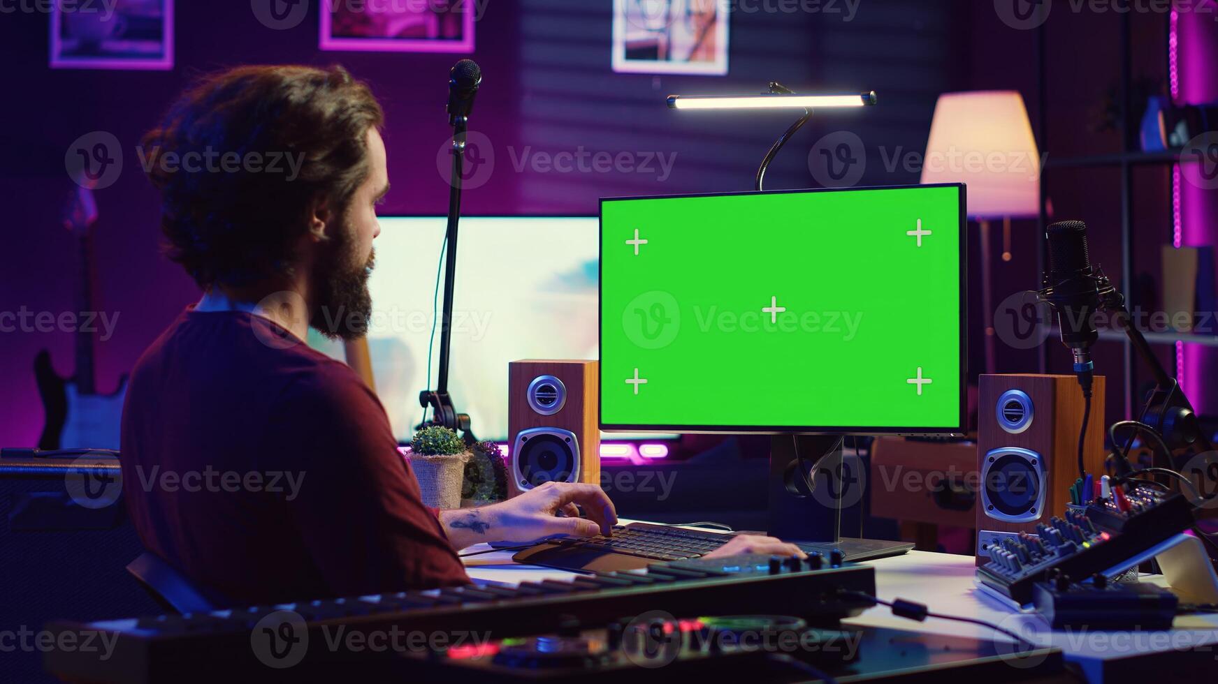 Sound engineer beginner learning acoustical engineering and mastering for music industry post production. Artist watches tutorial on greenscreen pc to use mixing console and equalizer. Camera A. photo