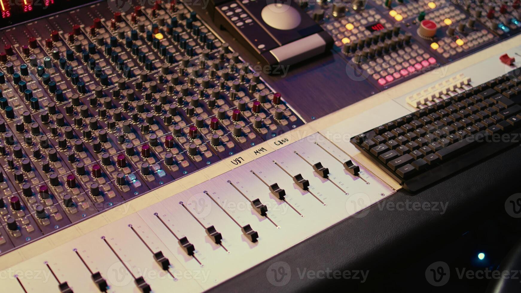 Empty professional studio with control desk mixer and pre amp knobs, music recording and editing with audio software. Control room buttons and sliders in post production, soundproof space. photo