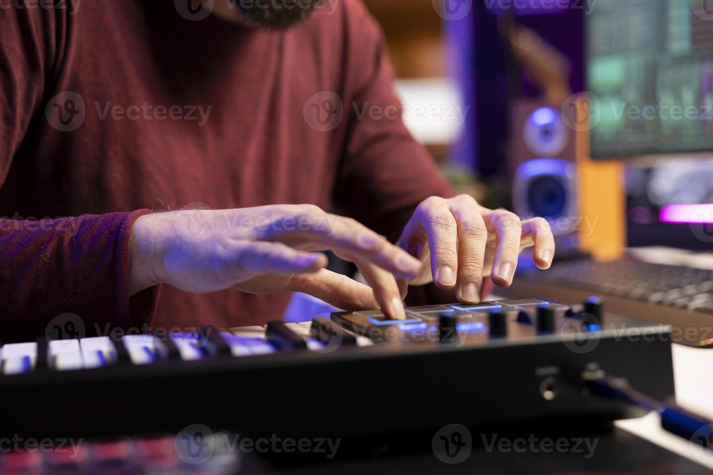Audio engineer works with recording gear in his home studio, learning to use mixing console and pre amp knobs to add sound effects on soundtracks. Artist editing new tunes, production techniques. photo