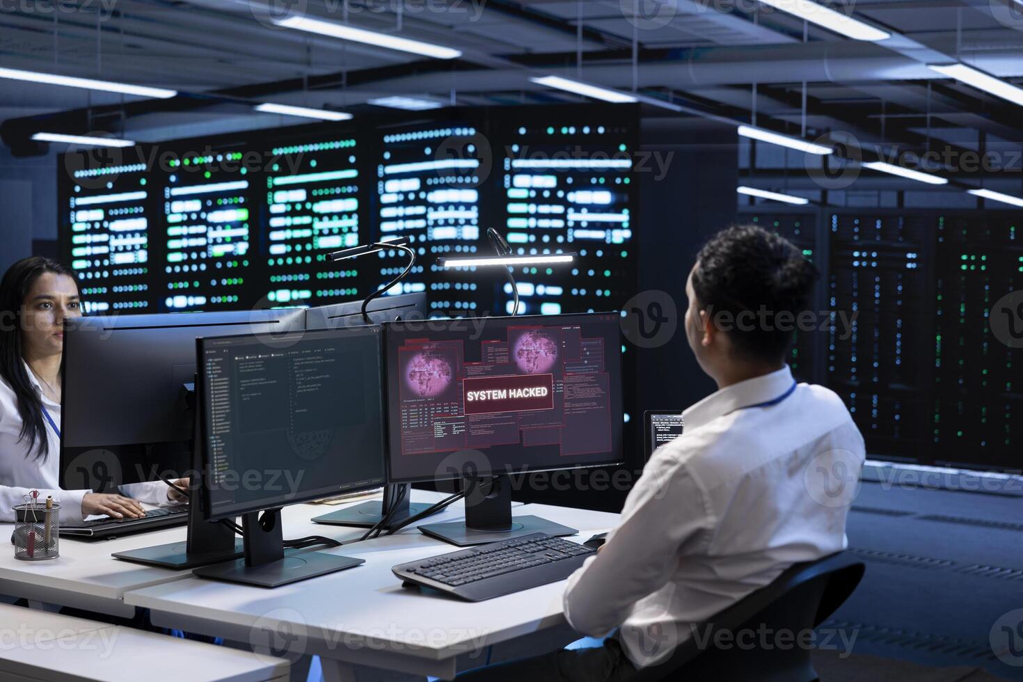 Teamworking developers in server room trying to protect hardware from cybercriminal attack. Data center cybersecurity division colleagues fighting malware during security breach photo