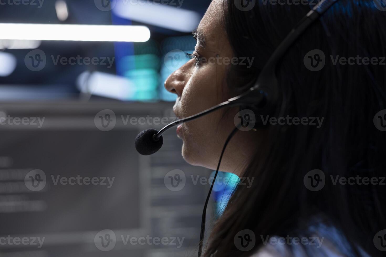 Data center operator assisting project teams with complex installations, issuing commands though headset mic. Expert in server hub communicating with engineers in remote call, close up photo