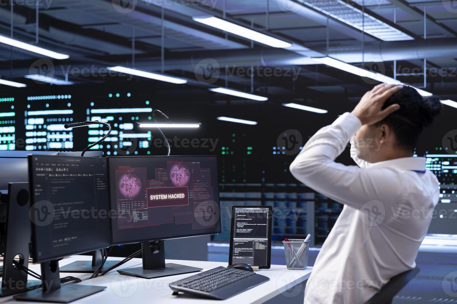 Technician in server hub doing face palm gesture, trying to protect hardware from hacker stealing information. Close up of data center employee stressed by security breach alert caused by virus photo