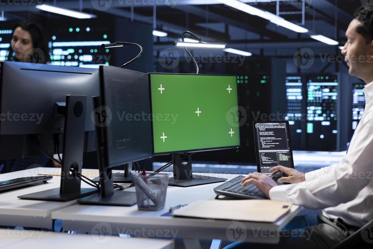 IT operators in data center checking equipment performance on isolated screen computer after upgrading infrastructure. Admins doing maintenance on supercomputers in servers room using chroma key PC photo