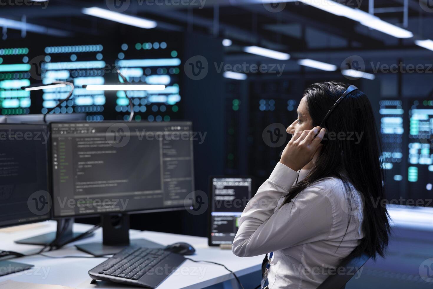 Admin in data center working on PC, providing technical support to customers, troubleshooting issues. High tech server hub worker carrying out operational technical interventions requested by clients photo