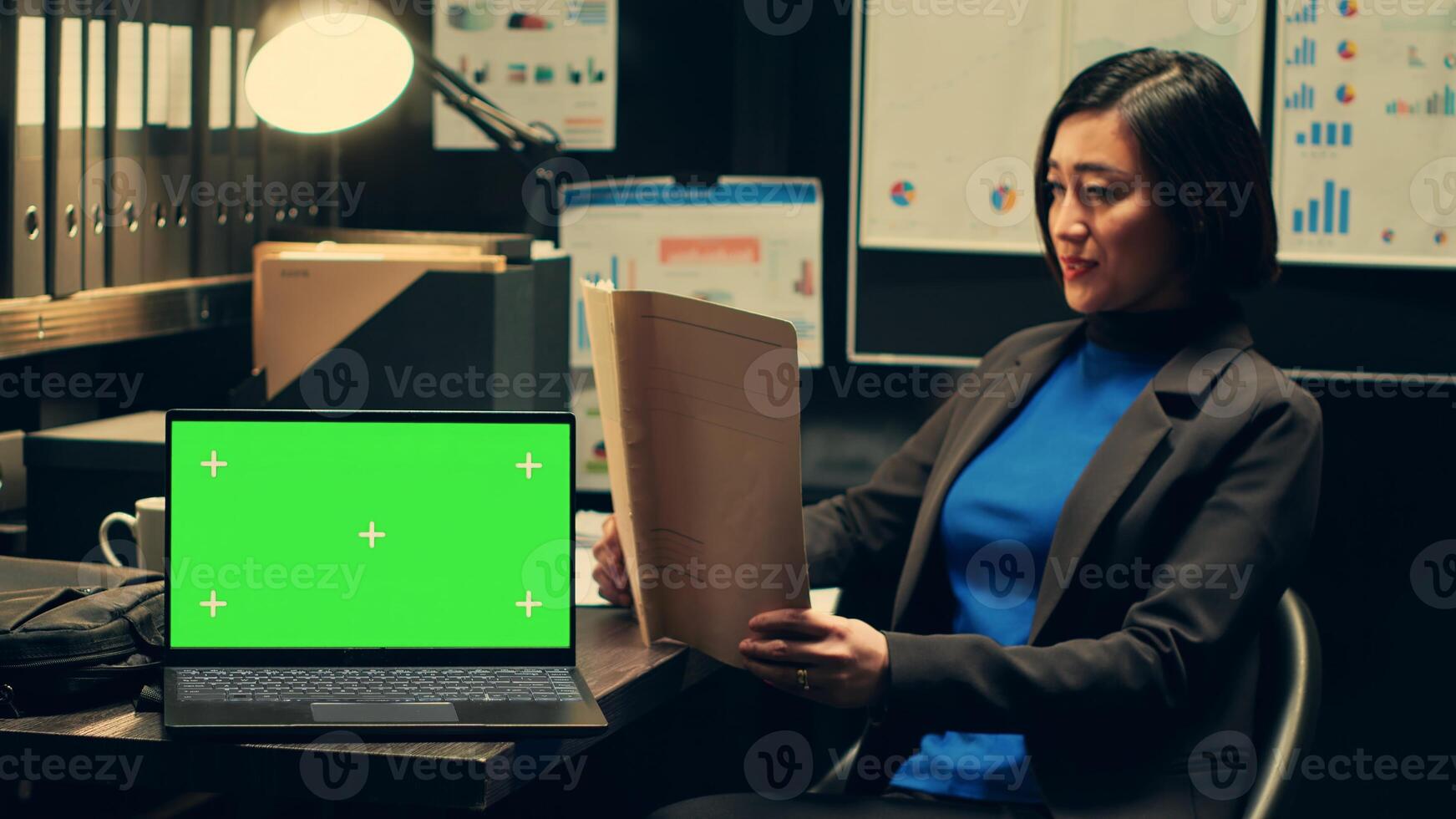 Private detective analyzing case files and uses greenscreen on pc, working on new investigation in archive room. Police officer reads archived folders, isolated chromakey template. Camera A. photo