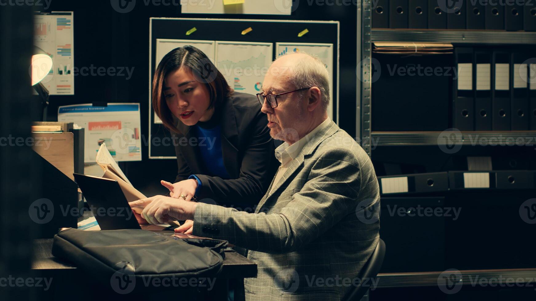 Inspectors team reviewing case information and reading witness statements to create a profile for the suspect. Detectives look into forensic evidence in police archive room, criminology. Camera A. photo