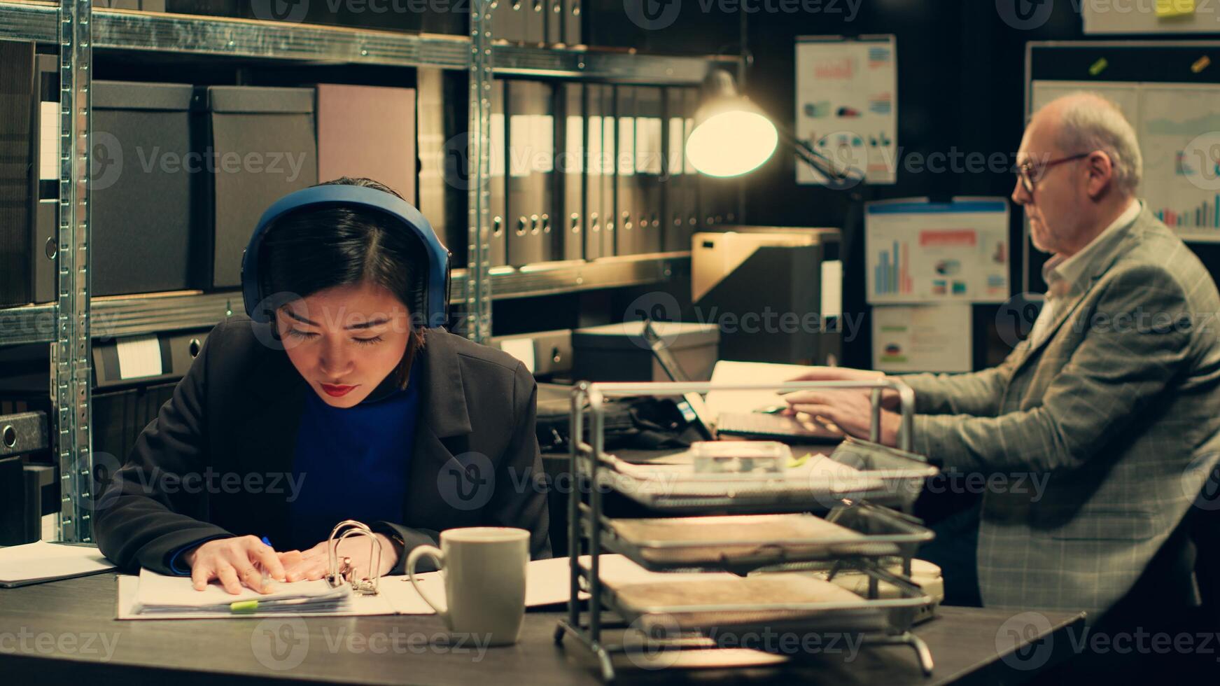Private detective extracting important ideas from witness statements, taking notes based on classified documents. Forensic expert looks into archived legal documents, listens to music. Camera A. photo