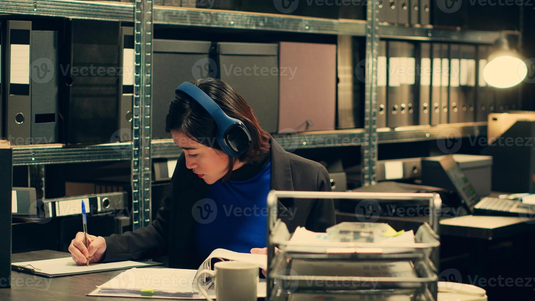 Agent extracting cryptic references found in classified records that may require further deciphering or analysis, archive room work. Law officer trying to break codes to find details. Camera A. photo