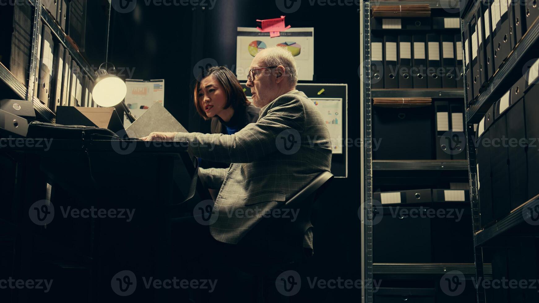 Investigators studying historical maps of crime scenes using federal classified records, officers reconstruct timelines using archived folders. Detectives conducting private investigation. Camera B. photo